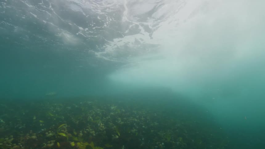 A wave crashes underwater