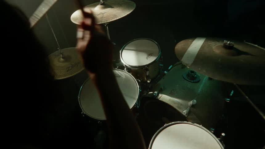 A person sitting and playing the drums with their hands