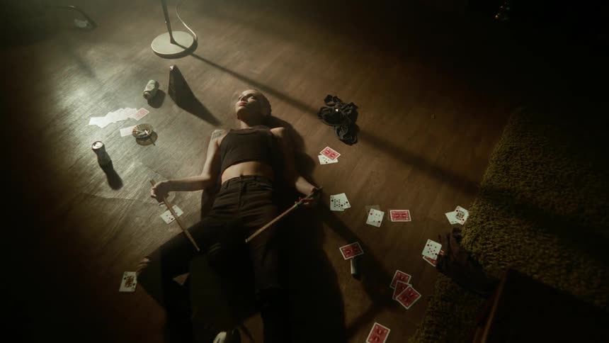 Woman rests on the living room floor surrounded by playing cards