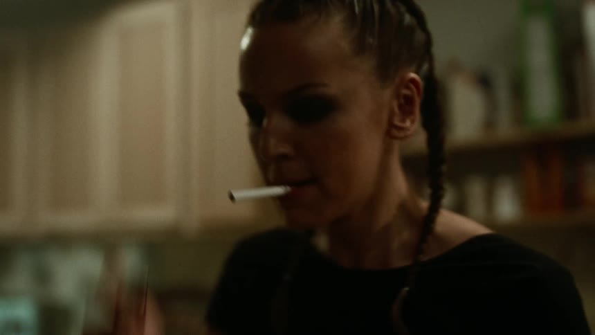 Mad woman lights a cigarette in the kitchen