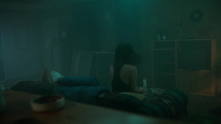 A sad young woman sitting on the sofa in the dark room