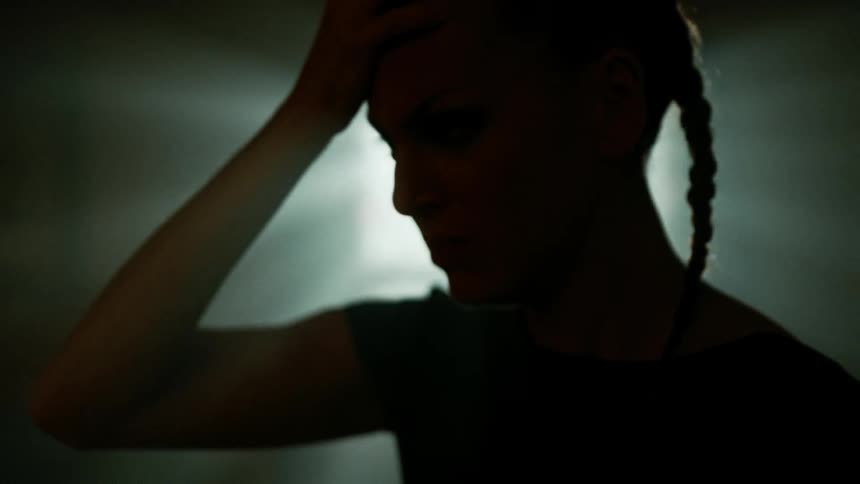 Young sad woman cries in the kitchen at home