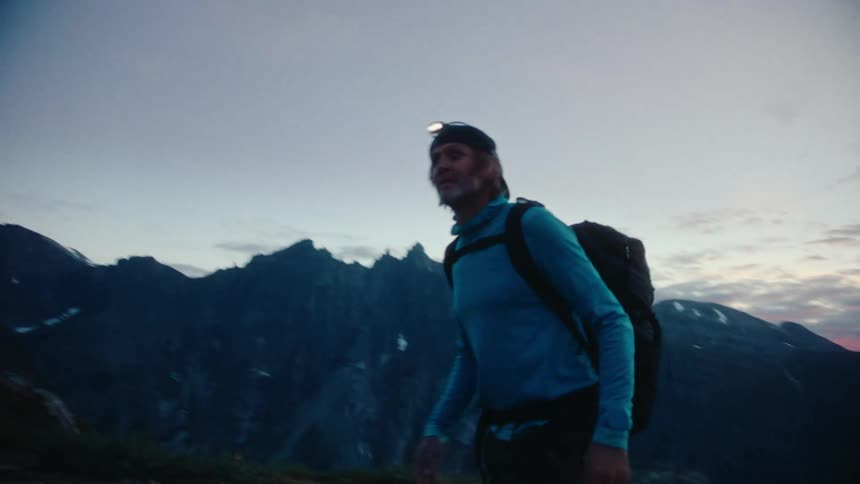 A man hiking on a mountain at dusk