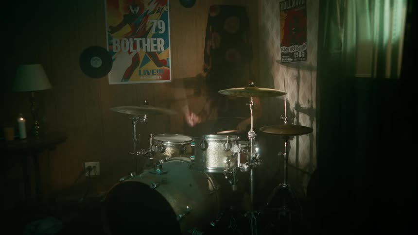 A girl is playing the drums in a room