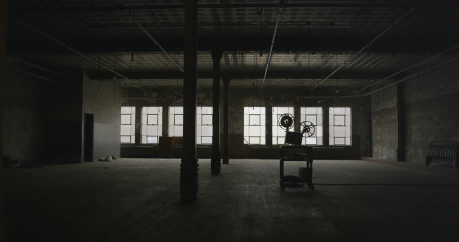 A old projector is sitting off in a large room