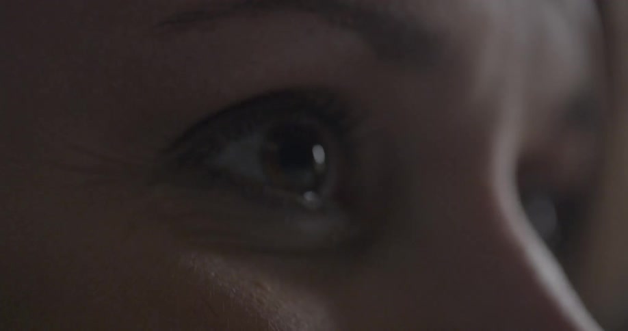 A person is staring forward blinking
