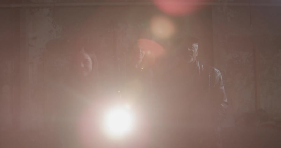 Three people watch something ahead from a projector