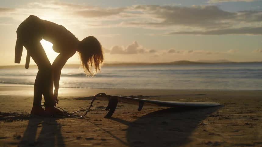 A surfer getting ready to surf at dawn