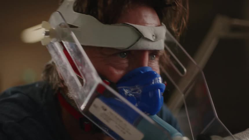 A concentrated man wearing an oxygen mask