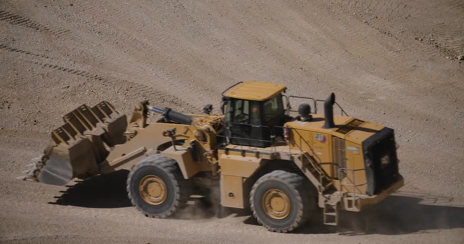A tractor moving through an area of dirt and sand