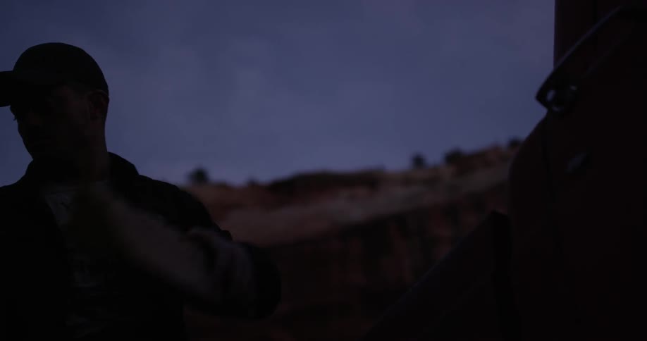 A man is lifting items in a dark area