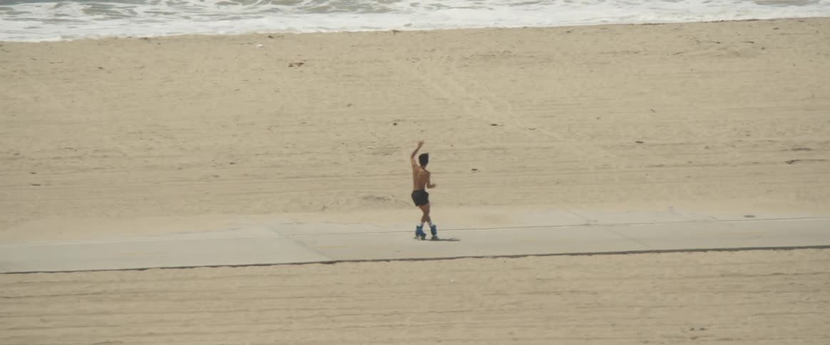 A man on the beach using roller skates and dancing