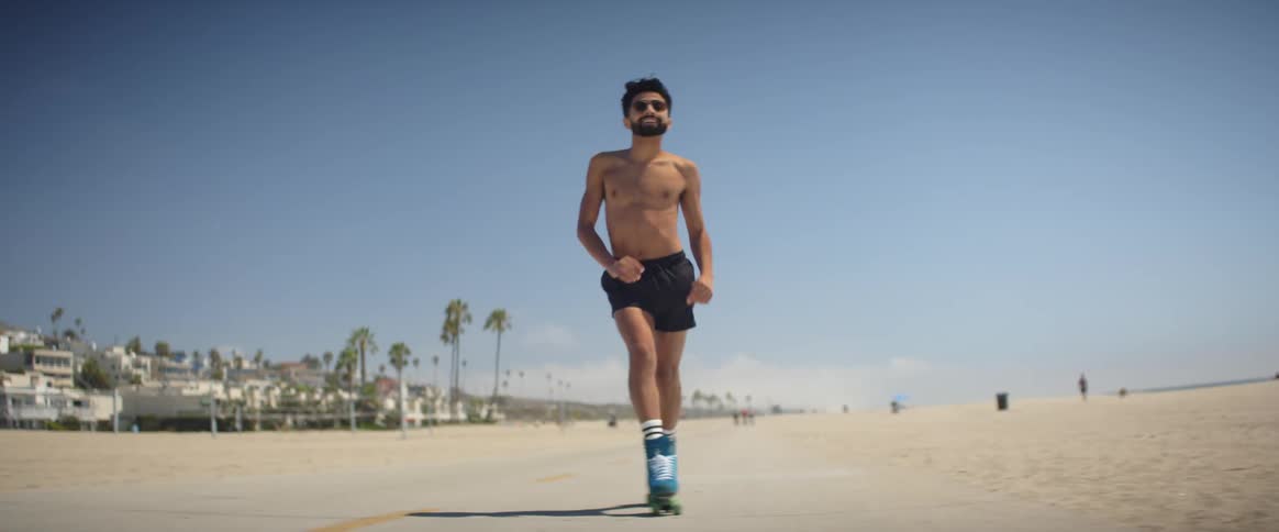 A man is roller skating on the beach