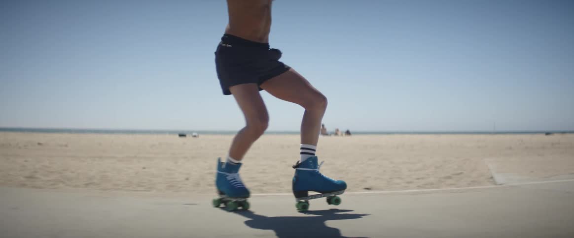 A man skating near a beach on a sunny day