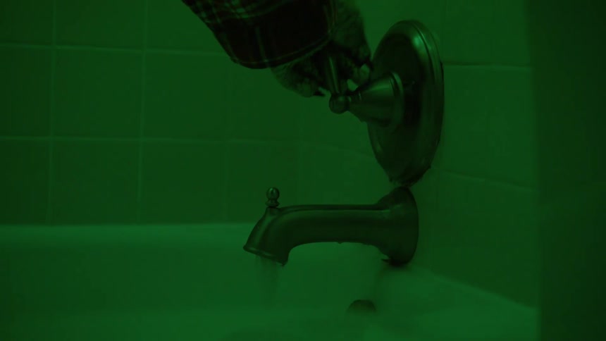 A closeup of a persons hand in costume turning on the tap and pouring water