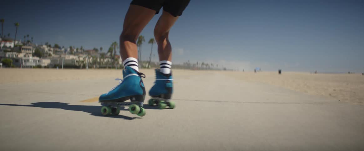 A man is rollerblading on the beach