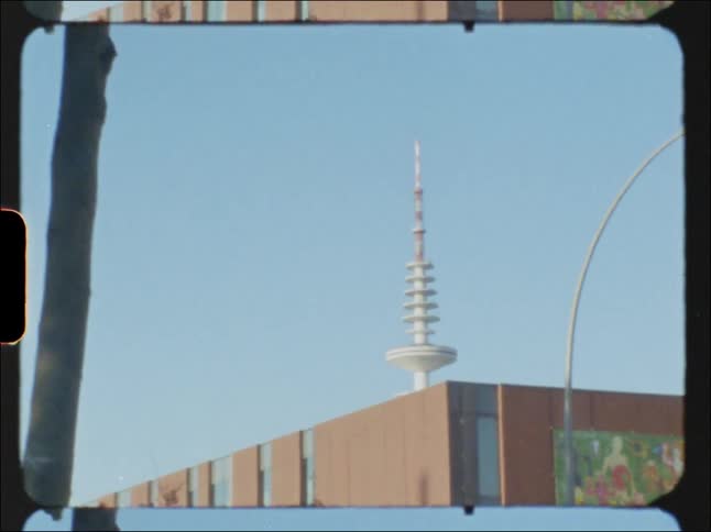 Large tower with series of disks towers over buildings
