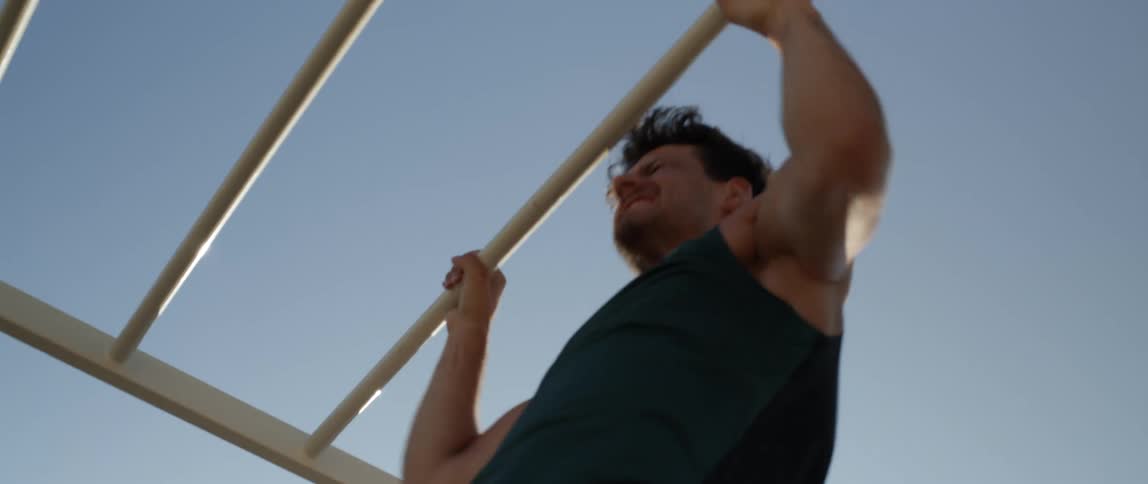 A man doing pullups with a facial expression of effort