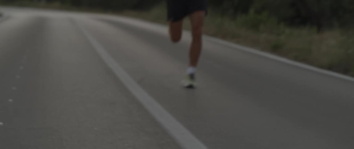 Man runs down road through countryside
