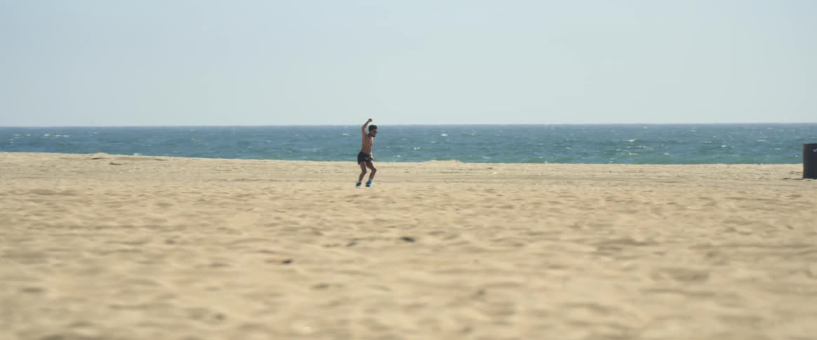 A man is roller skating on the beach