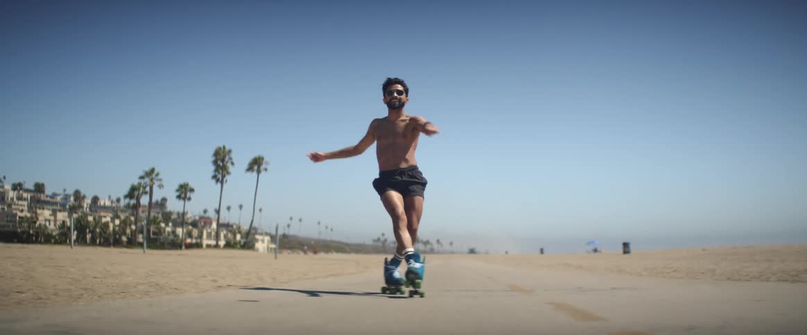 A joyful man dancing with roller skates on the seaside promenade