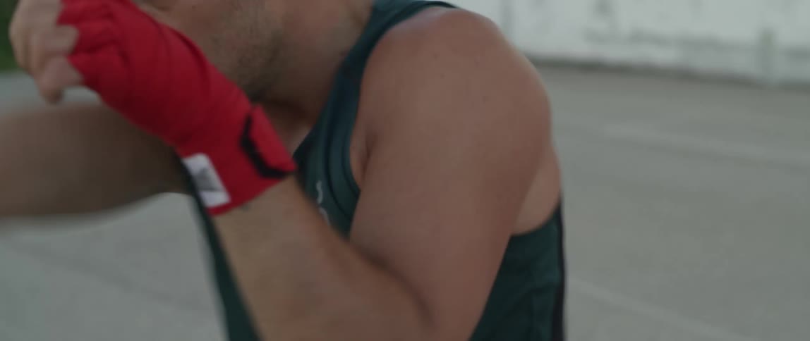 A man practicing fighting moves wearing red gloves