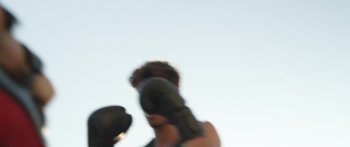 Two boxers training on a playground at sunset