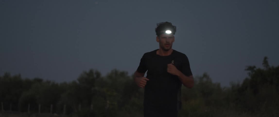 A man running in the forest at nightfall