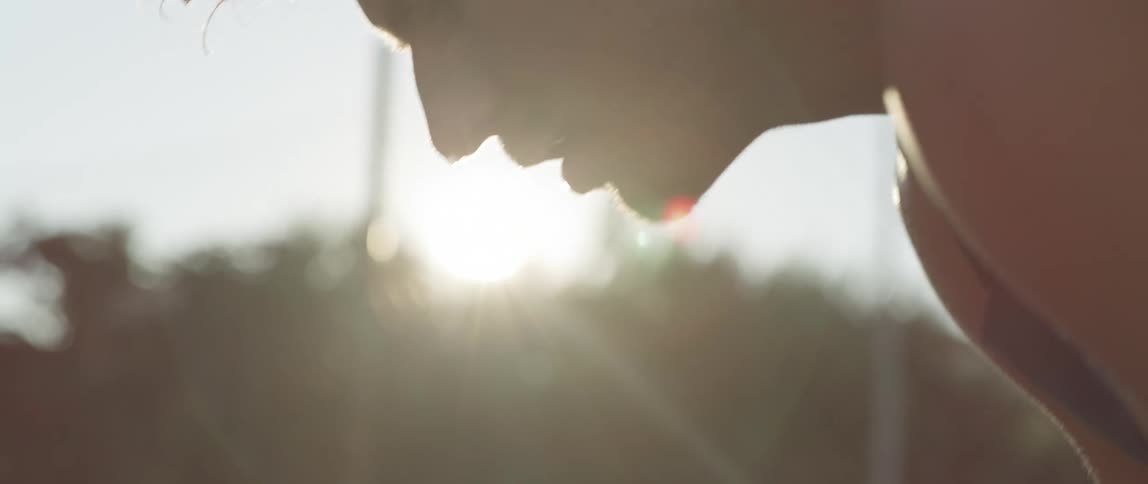 A man rests after running in the sunny morning