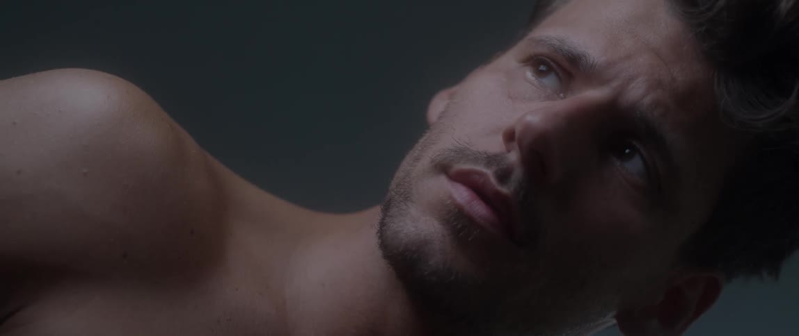 Bare chested man looks around and sighs