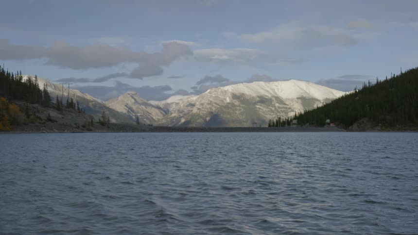 The water is rough in this lake before a mountain