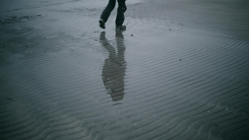 Person walking with their shadow visible on the ground