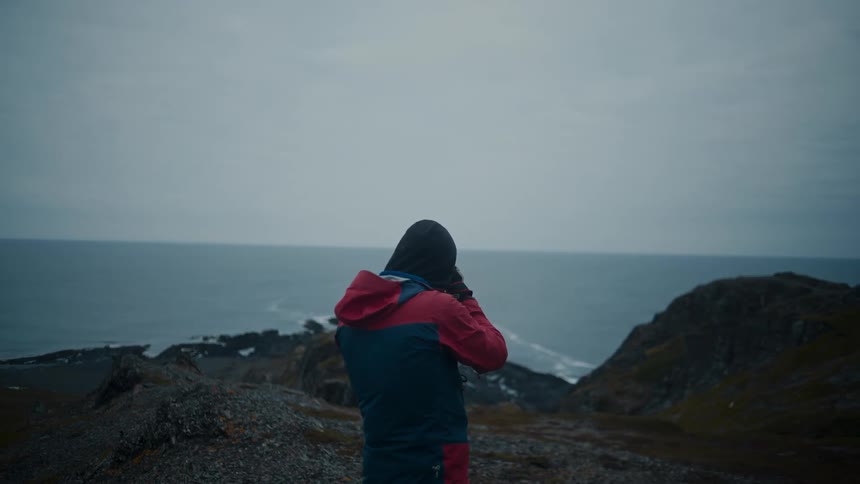A man is taking photos by the shore
