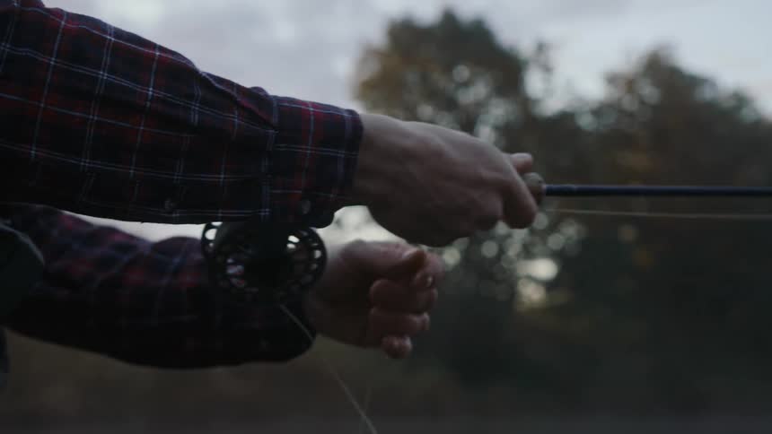 Hands holding a fishing rod