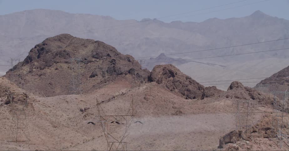 View of a chain of rocky mountains with electricity transmission towers