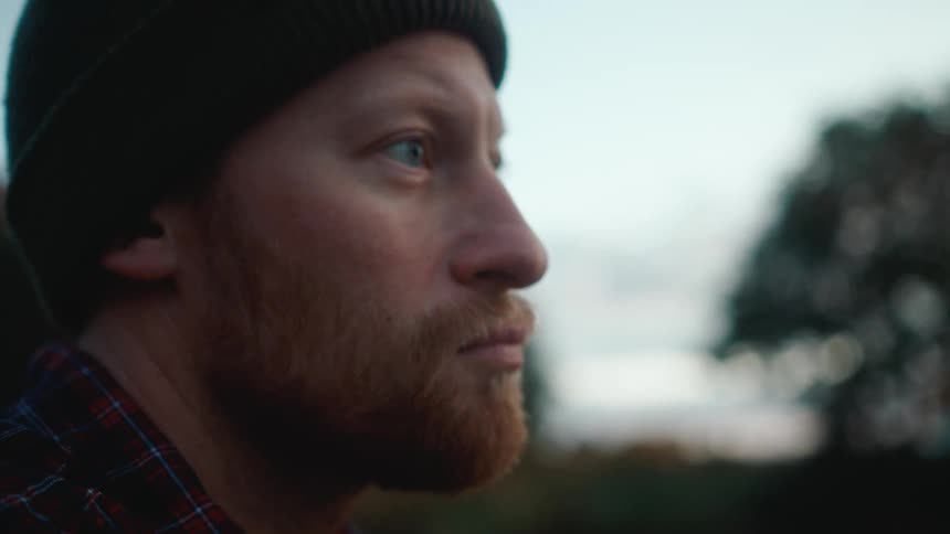 Man standing outdoors casts his fishing line