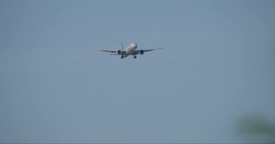 The plane is landing in the clear sky