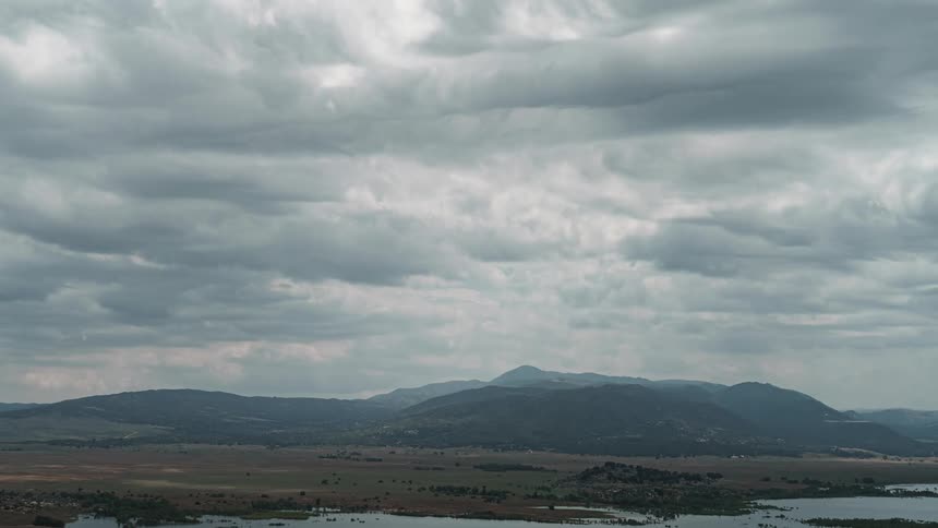 Dark clouds floating over mountains and river