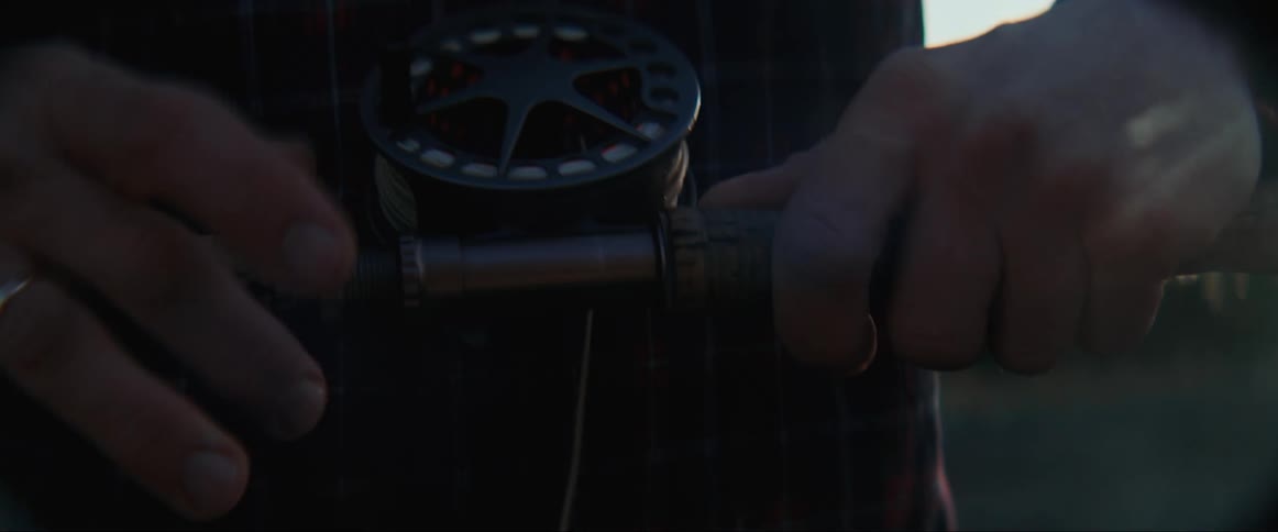Man sorting a thread with a tool at sunset