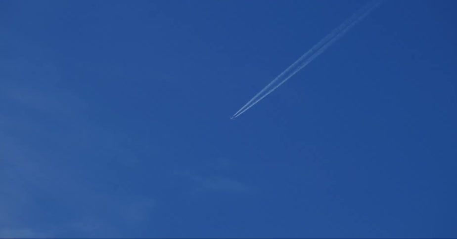 The plane leaving a contrail in the blue sky