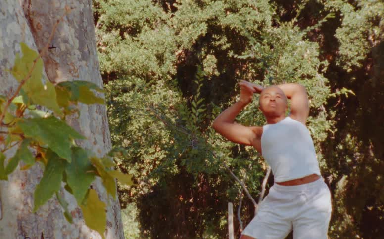 Woman dances with upper body movements near tree outdoors