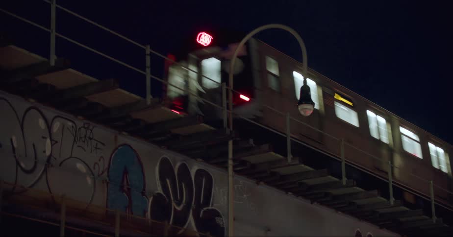 An elevated train passing a station at night