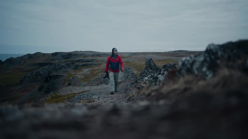 Photographer carries a camera on a gravel path in the countryside
