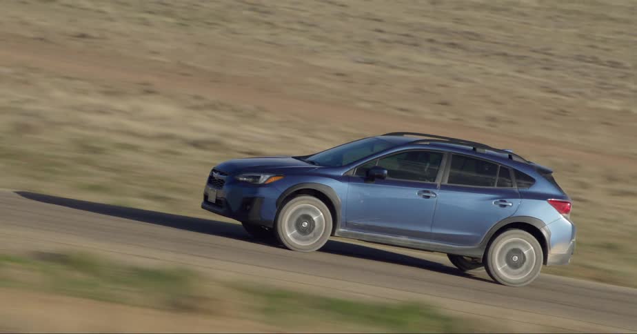 Blue suv car drives on country road in the field