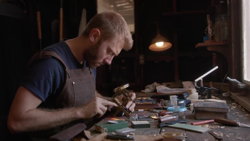 A man working indoor using a magnifier placed on the table