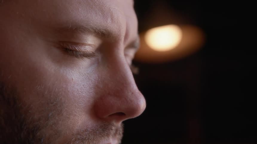 A man briefly closes his eyes