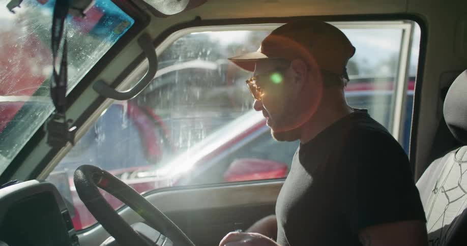 A man enters a van that is parked amongst other vehicles
