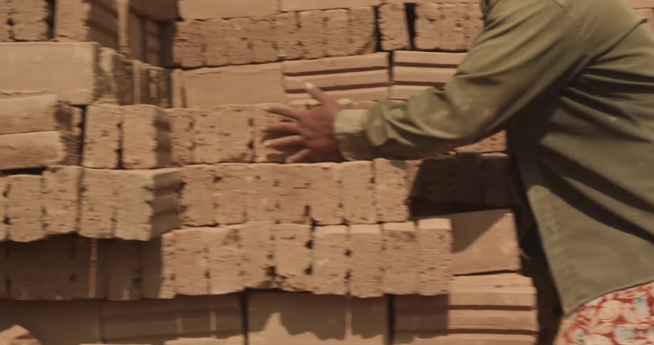 A worker stacking bricks