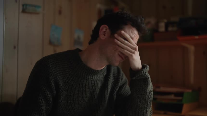 A man is sitting at the table reading a report