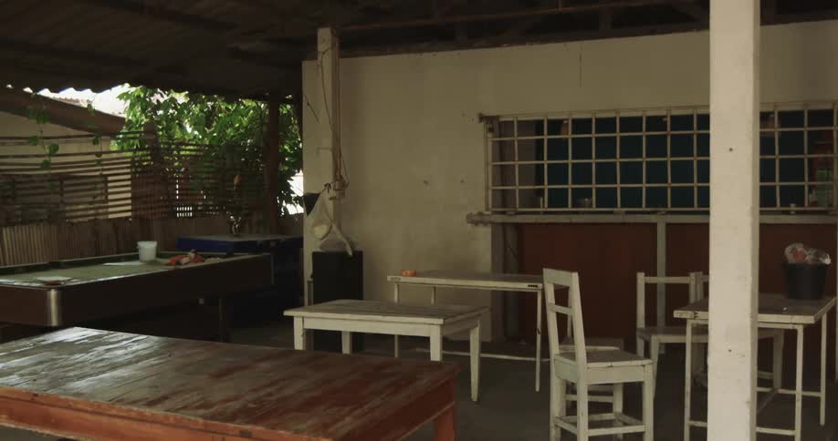 Multiple tables occupy large porch of building